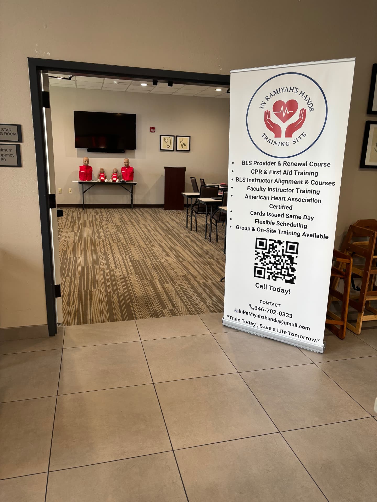 In RaMiyah's Hands training room with the training site banner at the entrance